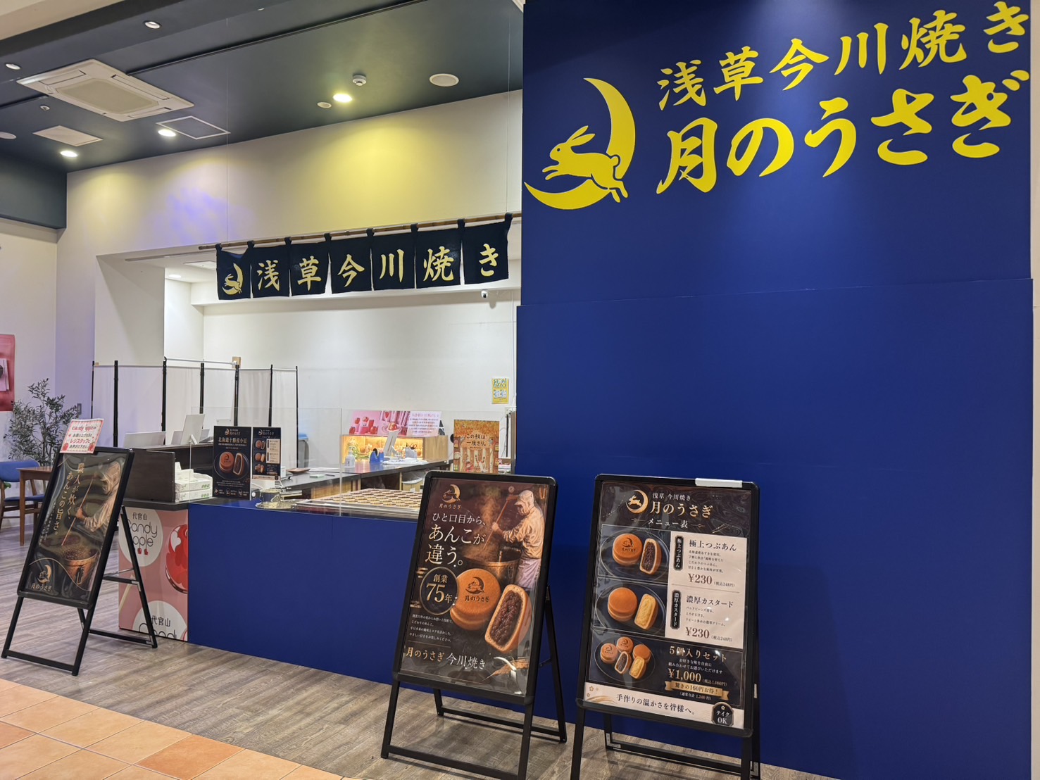 イオンモール高崎にある月のうさぎの店頭。月紺の壁面サインと販売カウンターが見える。