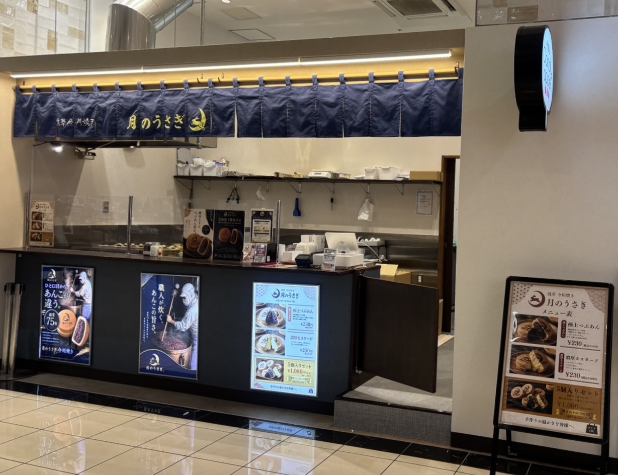 イオンモールりんくう泉南にある月のうさぎの店頭。月紺ののれんと販売カウンターが見える。